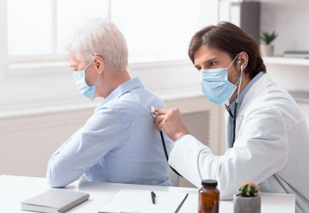 doctor using stethoscope listening to senior patients breathing - médico a examinar paciente imagens e fotografias de stock