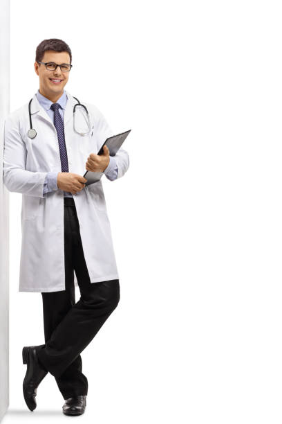 doctor with a clipboard leaning against a wall - doctor wall imagens e fotografias de stock