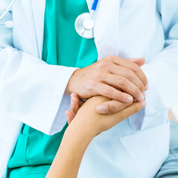 Doctor's hand consoling patient stock photo