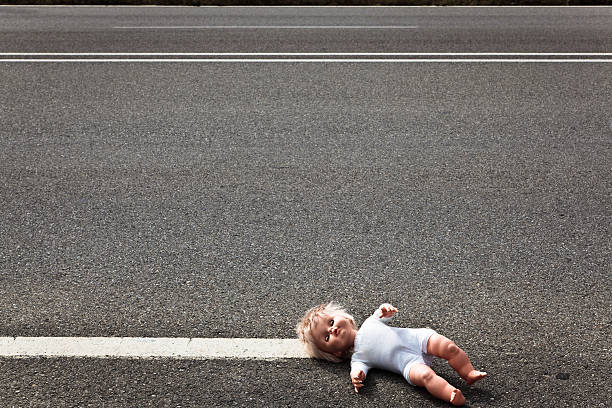doll leave on a highway lane doll leave on a highway lane after simulated car accident. broken doll 1 stock pictures, royalty-free photos & images