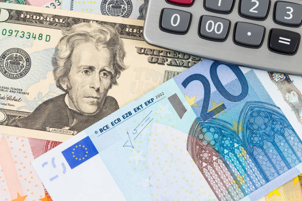 US Dollar and Euro banknote money with calculator stock photo