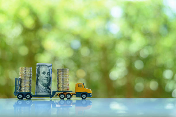 US 100 dollar banknote and rows of coins on a trailer truck. stock photo