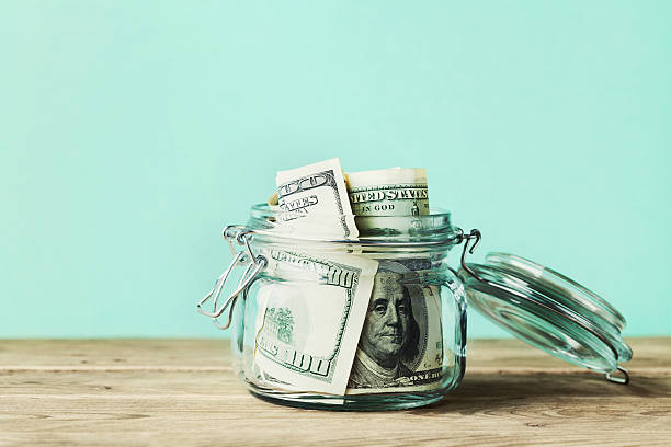 dollar bills in glass jar. saving money, economy, finance concept. - glazen pot stockfoto's en -beelden