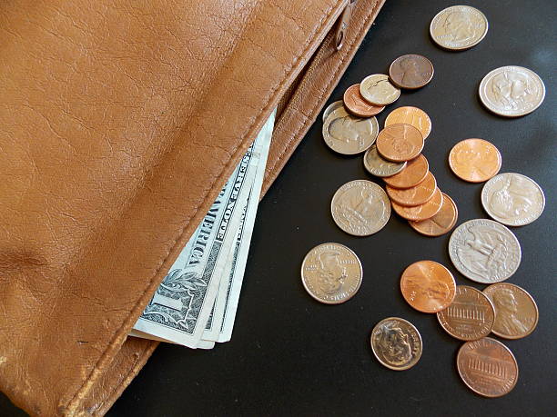 US Dollars and Coins Spilling Out of a Purse stock photo