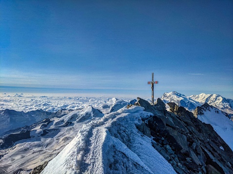 Dom 4545m . Highest mountain in Switzerland. Summit cross, valais alps. mountaineering, rock climbing. blue sunny sky