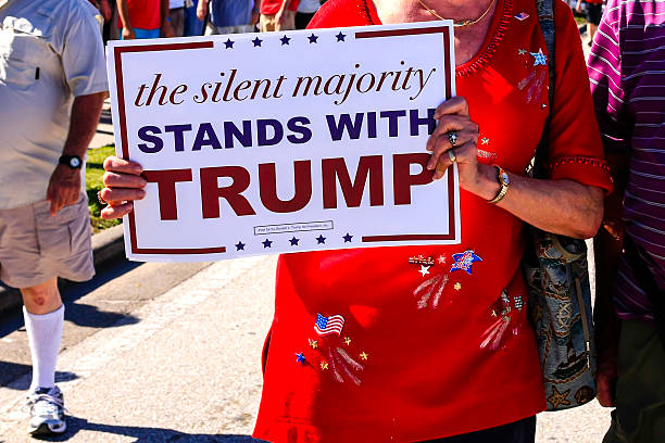 Donald Trump supporter holding pro-trump poster Sarasota, FL, USA - November 28, 2015: White seniors holding a placard supporting Donald Trump showing their support at his Presidential candidacy visit to Sarasota FL donald trump stock pictures, royalty-free photos & images