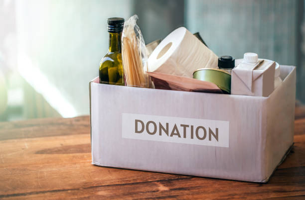 Donation box with food and toilet paper on the wooden desk. Covid-19 outbreak, self-isolation stock photo