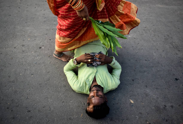 Dondi in chhath Festival A women is performing Dondi (a ritual part of chhath festival where devotees cross the body of laying man, children, women for devotion) on the occasion of Chhath festival in Kolkata, India. chhath stock pictures, royalty-free photos & images