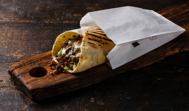 Doner Kebab Gyros Shawarma beef roll in pitta bread Wrap sandwich Doner Kebab Gyros Shawarma beef roll in pitta bread Wrap sandwich on wooden background shawarma stock pictures, royalty-free photos & images