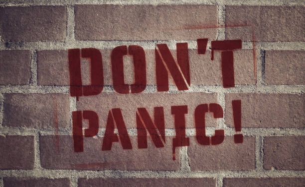 "Don't Panic!" Stencil Spray-Painted on Brick Wall stock photo