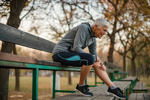 Don't put too much pressure on your body Image of Senior Woman Runner Hold Her Sports Injured Knee Outdoor. Injury From Workout Concept. Mature Woman Suffering From an Knee Injury While Exercising and Running knee stock pictures, royalty-free photos & images