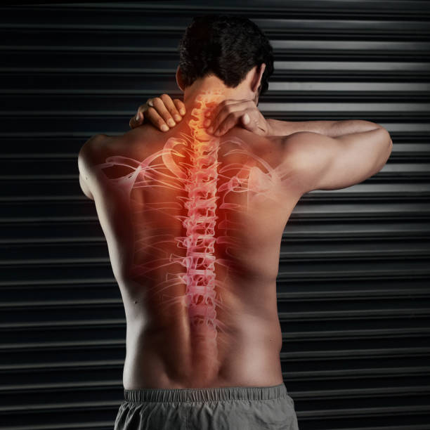 Don't risk a spinal injury Studio shot of a muscular young man rubbing his neck with his spinal column showing through cgi spine body part stock pictures, royalty-free photos & images