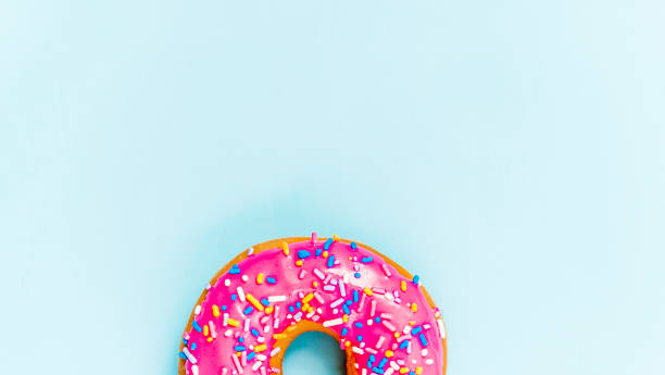 Donut with pink icing and copy space Donut with pink icing and copy space sugar food stock pictures, royalty-free photos & images