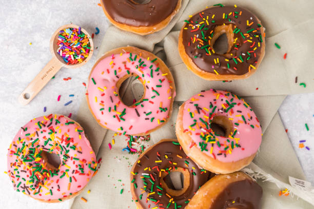 Donuts on a green linen with sprinkles stock photo