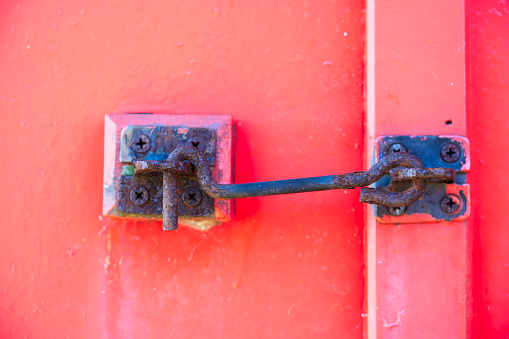latch on the iron door. A wooden stick is inserted instead of a padlock.