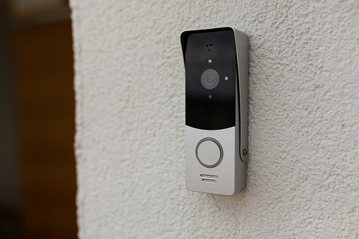 doorbell on the wall of the house with a surveillance camera