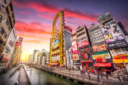Tourists at Dotonbori shopping street at sunset. Dotonbori is the famous destination for traveling and shopping in Osaka, Japan.