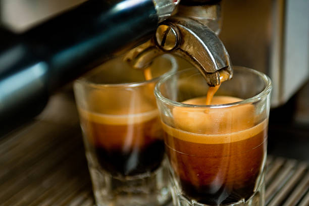 Double Espresso Shot Dual espressos being made from a commercial grade machine in a local coffee shop.  Shots are being made into glass shot glasses.  Crema on the top shows that this is high quality coffee. espresso stock pictures, royalty-free photos & images