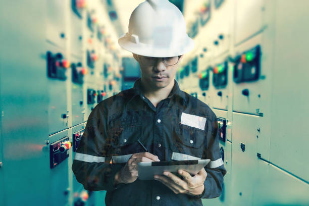 Double exposure of  Engineer or Technician man working with tablet in switch gear electrical room of oil and gas platform or plant industrial for monitor process, business and industry concept. stock photo