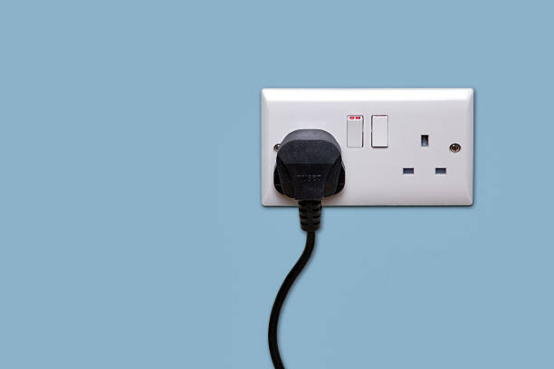 Double power socket and single plug switched on Double electrical power socket and single plug switched on, blue background. electric plug photos stock pictures, royalty-free photos & images