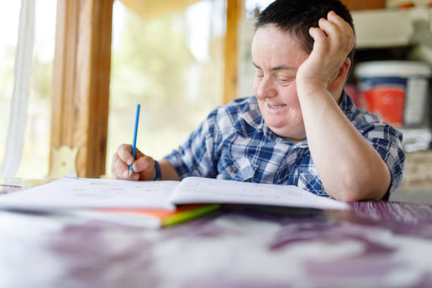 Down syndrome woman drawing stock photo