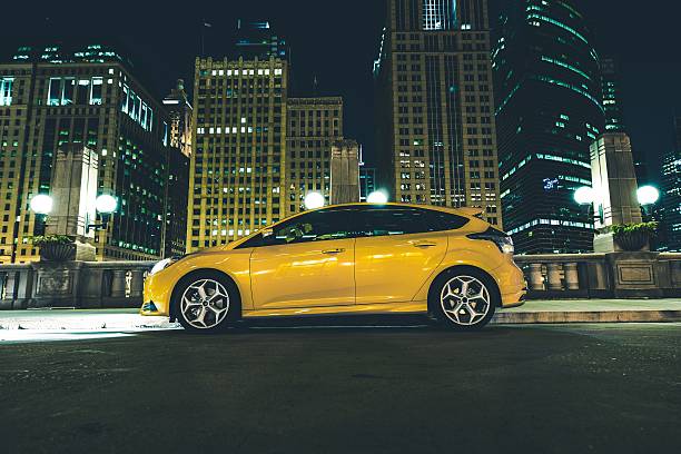 Downtown Parked Car Downtown Parked Car at Night. Downtown Chicago Parking Space. Five Doors Yellow Car with Lights On. hatchback stock pictures, royalty-free photos & images