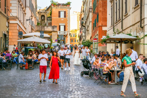 Dozens of customers enjoy life sitting outside a bar in the Monti district in the heart of Rome stock photo