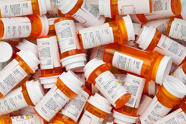dozens of prescription pill bottles - fles stockfoto's en -beelden