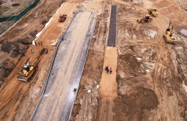 Dozer levels the ground during road construction, aerial view. stock photo