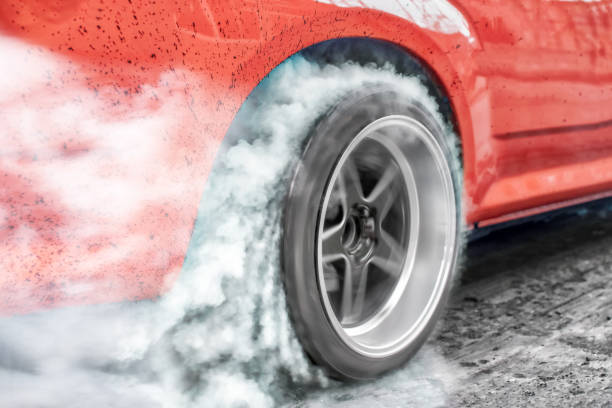 Drag racing car burns rubber off its tires in preparation for the race stock photo
