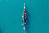 istock Dragon Boat team rowing to the pace of an onboard Drummer. 1292119381