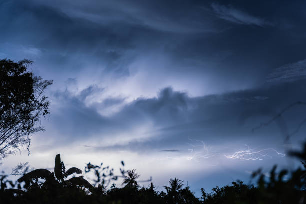 Dramatic lightning thunderstorm striking in the night sky over rural landscape stock photo