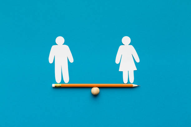 Drawn scales with words man and woman Gender equality in corporate world. Figures of man and woman on pencil seesaw, blue background, copy space male likeness stock pictures, royalty-free photos & images