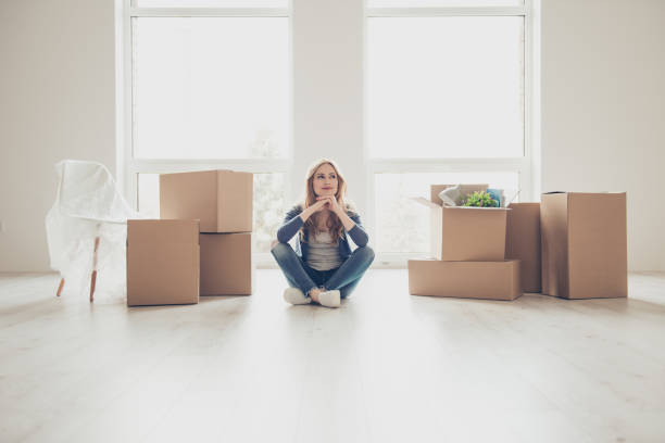 Dream come true! Portrait of young pretty woman sitting on the floor and thinking how to unpack all the stuff Dream come true! Portrait of young pretty woman sitting on the floor and thinking how to unpack all the stuff unpacking stock pictures, royalty-free photos & images