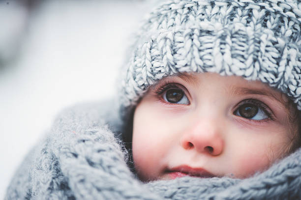 dreamy cozy outdoor portrait of toddler child girl in winter stock photo