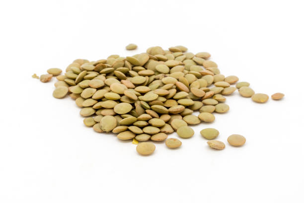 Dried green lentils against a white background stock photo