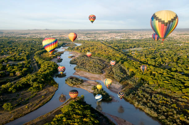 Drifting Over the River Hot air balloons drifting over the Rio Grande river in Albuquerque, New Mexico. new mexico stock pictures, royalty-free photos & images