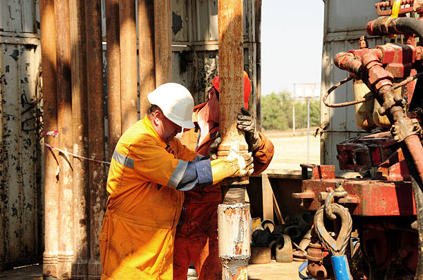 Drilling rig workers in orange uniform stock photo