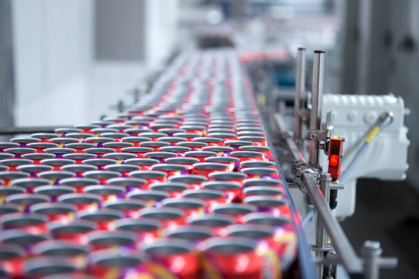 Drink Cans on the Production Lines Filling of colorful beverage cans on production line. food and beverage industry stock pictures, royalty-free photos & images