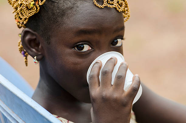 drinking water for life african girl drinks water out cup - africa cup stockfoto's en -beelden