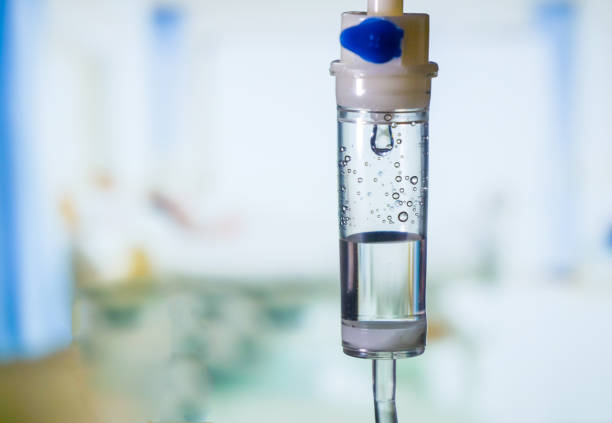 Dripping medical perfusion close up equipment in clinic background. Saline Solution IV Drip Fluid for Infusion in Hospital. Intravenous infusion tube equipment in hospital. antiviral treatment  infusion therapy stock pictures, royalty-free photos & images