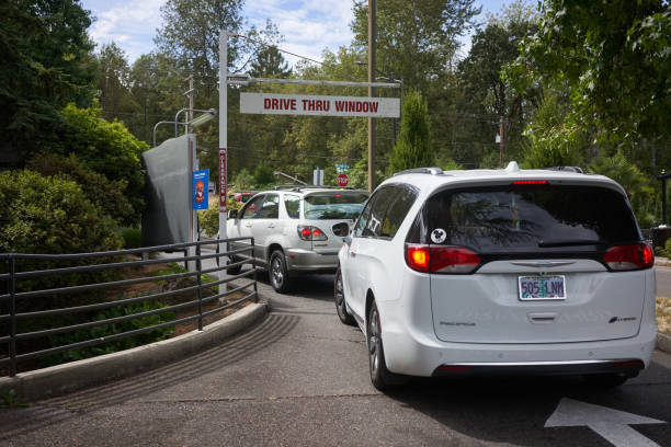 Drive Through West Linn, OR, USA - Aug 20, 2020: Cars line up outside the drive thru window at a Burgerville restaurant in West Linn, Ore., during a pandemic summer. Burgerville is an American fast food chain. drive thru queue stock pictures, royalty-free photos & images