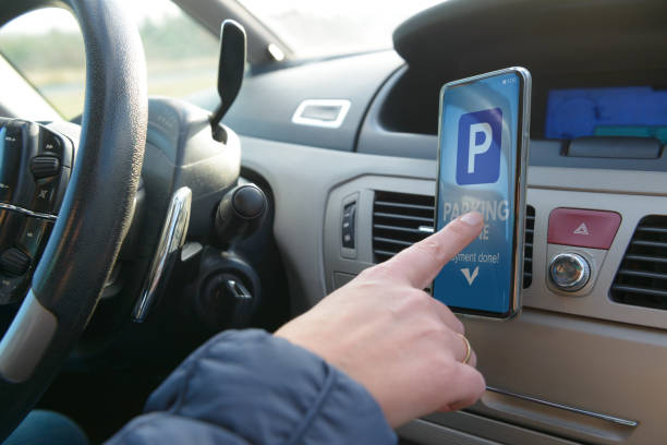 Driver using smartphone app to pay for parking stock photo