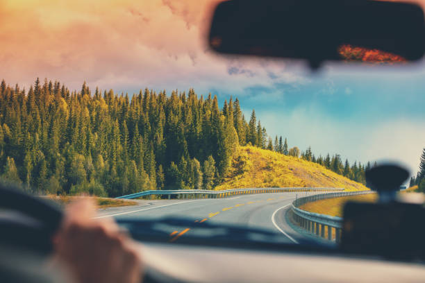 在山路上開車。從挪威美麗的大自然的擋風玻璃上觀看 - 自駕遊 個照片及圖片檔