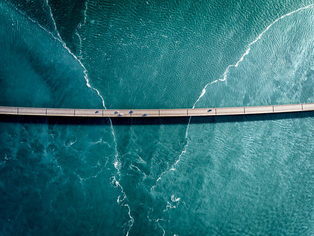 Driving on a bridge over deep blue water stock photo