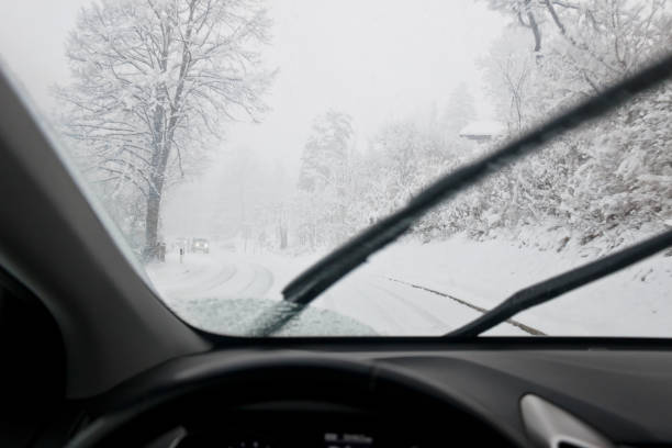 Driving on a country road during a blizzard with oncoming vehicles stock photo