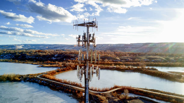 Drone Image of a Cellular Tower in front of Lakes Beautiful shot of a modern cellular phone tower in a pretty setting with beautiful clouds telephone pole photos stock pictures, royalty-free photos & images