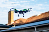 istock Drone quad copter flying over the roofs. Drone photography and videography. Toy drone. Copy space 1345327585