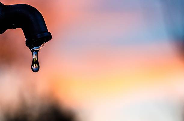 drop of water coming out of a metal tap - droogte stockfoto's en -beelden