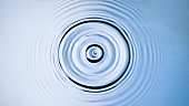 istock Droplet creating a splash and ripples when hitting the surface 1328838367